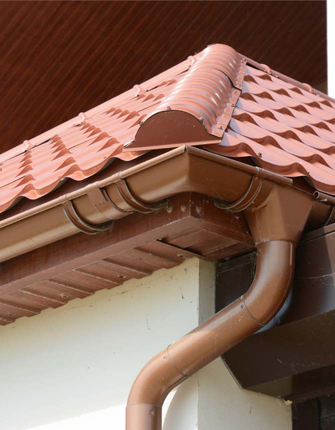 Custom brown gutter installation integrated seamlessly with a clay tile roof system in Vallejo , backed by a 10-year workmanship and labor warranty.