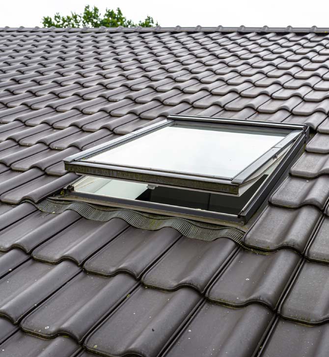 Energy-efficient skylight installed on a durable dark tile roof in Vacaville, improving home ventilation and natural light as part of a complete roof system remodel by Capital Roofcare.