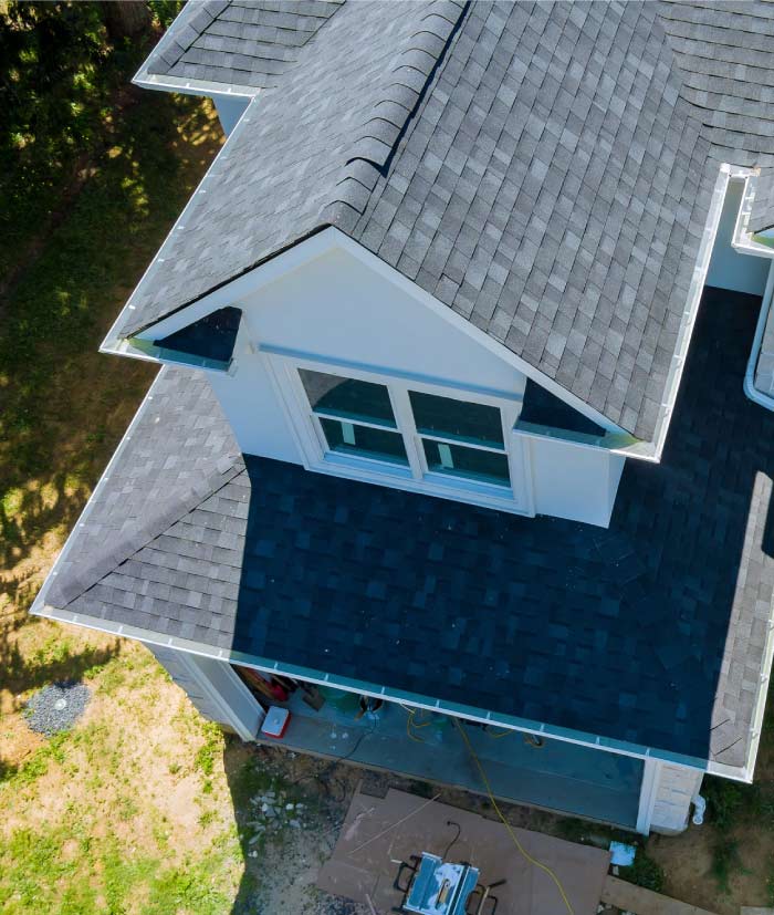 High-angle aerial view of a modern residential home in the Bay Area featuring a newly installed charcoal grey architectural shingle roof with clean white trim and integrated gutter systems.