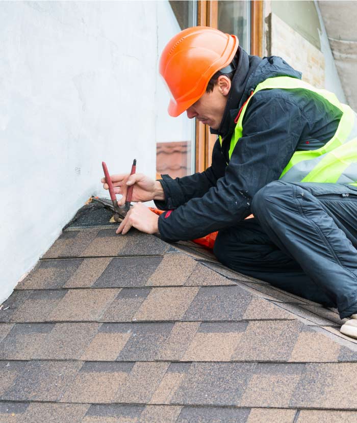 Capital Roofcare specialist performing precision flashing repair on a shingle roof to prevent water intrusion and dry rot damage.