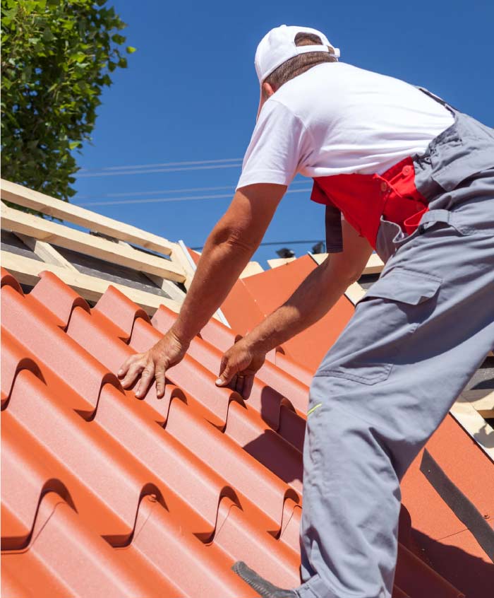 Licensed roofing contractor manually installing premium Spanish clay tiles on a steep-slope residential roof in Vallejo.