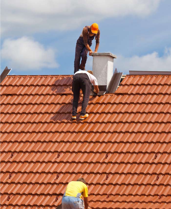 Professional roofing team collaborating on a complex chimney flashing tile roof repairs and tile installation for a residential property in the Greater Sacramento area.