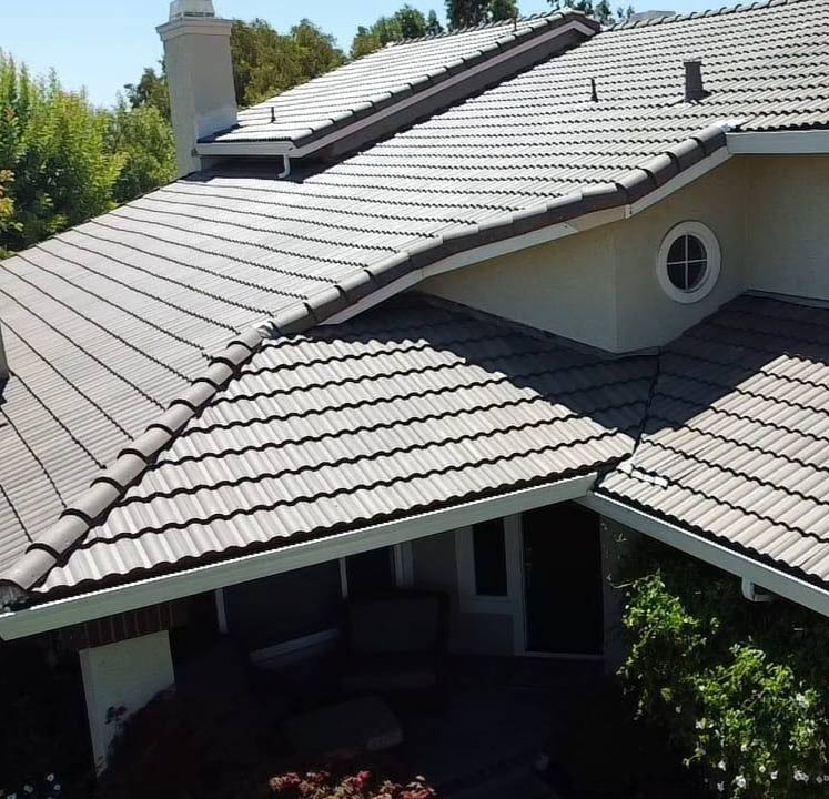 Close-up of a vibrant red tile roof system in Vacaville with a custom dormer window, installed by Capital Roofcare & Renovation to provide sustainable, long-term weather protection for local homes.