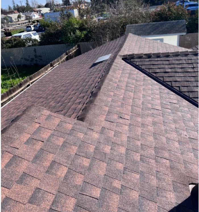 Detailed view of damaged architectural shingles and exposed underlayment being prepared for a professional fix roof shingles service in Vacaville.