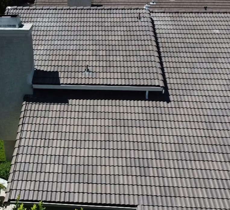 Large residential property with beige vinyl siding, stone veneer base, and a complex multi-level architectural shingle roof system, after residential roofing near me in vacavile, ca